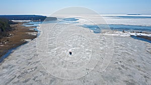 An expedition vehicle is reading on a huge ice floe in the middle of a frozen lake. Polar Pathcutter. Orange Behemoth on