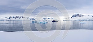 Expedition vessel in front of Antarctic iceberg landscape at Portal Point