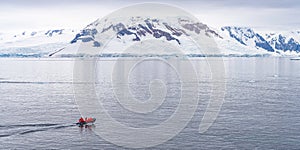 Expeditions - Zodiac with tourists cruises through Antarctic iceberg landscape at Portal Point