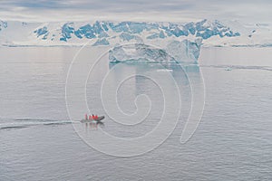 Expeditions - Zodiac with tourists cruises through Antarctic iceberg landscape at Portal Point