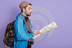 Expeditor backpacker map look orienteering direction, holding topographic map, expeditor find right way, guy wearing black jacket
