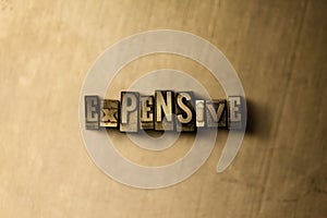 EXPENSIVE - close-up of grungy vintage typeset word on metal backdrop