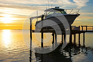 Expensive fishing boat on motorized electric dock vessel lift at sunrise photo