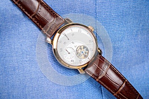 Expensive hand watch. Leather wristwatch on blue. Deadline or time management. Mens wristwatch. Luxury life and success