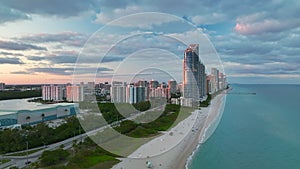 Expensive highrise hotels and condos over sandy beachfront on Atlantic ocean shore in Sunny Isles Beach city at sunset