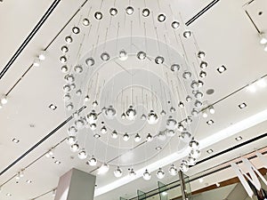 Expensive interior. Large electric chandelier made of transparent glass beads. White ceiling decorated with stucco molding.