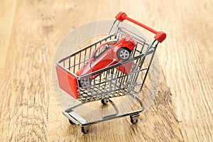 Expensive sports car in a shopping cart