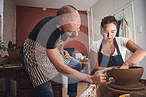 The experience is as important as the finished piece. a young man and woman working with clay in a pottery studio.