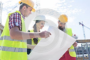 Experienced architect analyzing a blueprint on the construction site