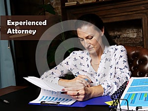 Experienced Attorney inscription. Female office workers with yellow shirt holding and writing documents on office desk