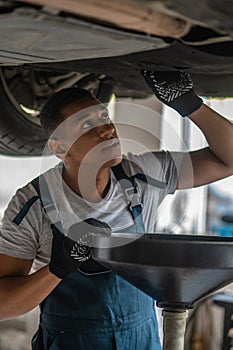 Experienced auto repair worker diagnosing car problem
