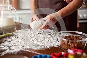 Experienced baker with a bulky piece of dough in hands