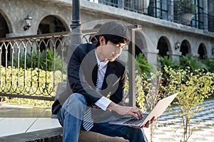 Experienced businessman. picture of a businessman. Asian businessmen sit looking laptop in front of modern office buildings