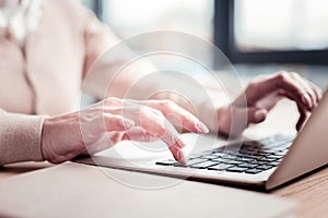 Experienced career woman typing accounting record on her laptop