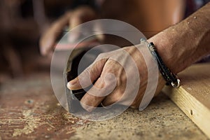 Experienced carpenter in work clothes. small business owner working in woodwork workshop, using sandpaper for polishing