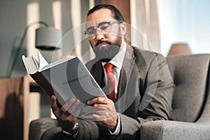 Experienced concentrated bearded lawyer reading administrative law