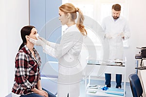 Experienced cosmetic surgeon looking at her patient