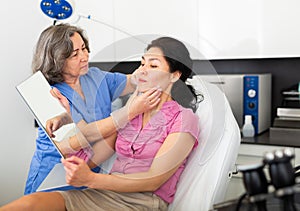 Experienced cosmetology doctor examines a young woman patient before the procedure