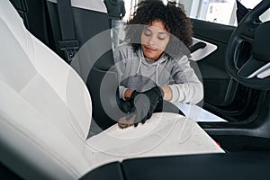 Experienced detailer brushing upholstery in vehicle interior