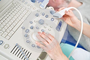 Experienced diagnostician adjusting settings before ultrasonography procedure