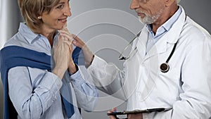 Experienced doctor informing lady about positive treatment results, good news