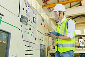 Experienced electrician working in power plant control room. Engineer working on the checking status switchgear electrical energy