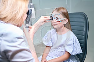Experienced female optometrist carrying out dynamic retinoscopy on child photo