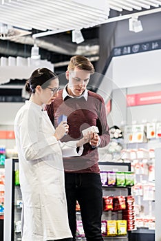 Experienced pharmacist checking the indications of a medicine photo