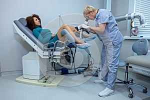 Experienced gynecologist doing colposcopy to a woman photo