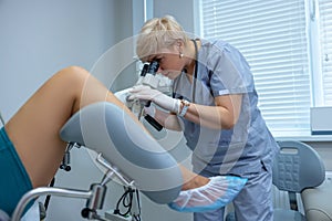 Experienced gynecologist doing colposcopy to a woman photo