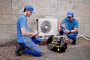 Experienced Hispanic HVAC Technician Installing Commercial Air Conditioning