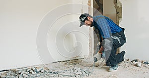 Experienced laborer working for years on construction sites renovates an apartment finishes a house, scrapes a floor has