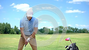 Experienced male golfer hitting ball at course, training before competition