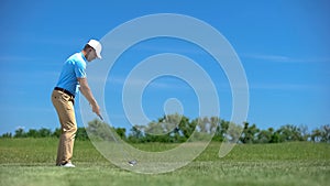 Experienced male golfer hitting ball in swing position, elite hobby and sport