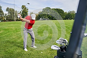 Experienced male golfer training on the course