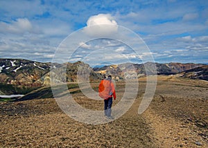 Experienced male hiker hiking alone into the wild admiring volcanic landscape with heavy backpack. Travel lifestyle adventure