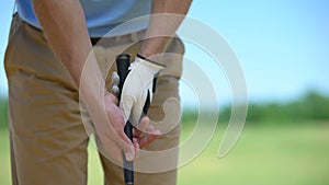 Experienced man golf player in white glove holding iron club ready to sport game