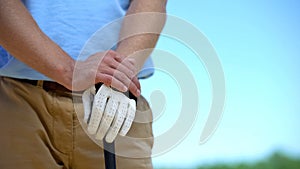 Experienced man golf player in white glove holding iron club ready to sport game