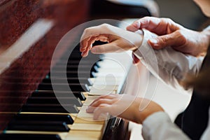 Experienced master piano hand helps the student