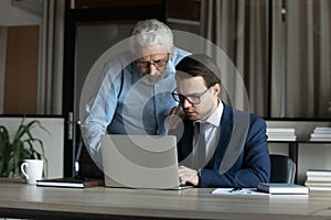 Experienced mature businessman consult young employee on solving business problem