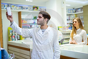 Experienced pharmacist counseling female customer in pharmacy