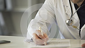 Experienced physician completing health insurance claim form, healthcare