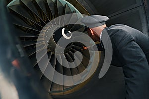 Experienced pilot inspecting the turbofan engine before the flight