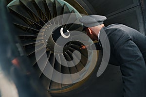 Experienced pilot inspecting the turbofan engine before the flight photo