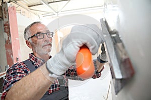 Experienced plasterer working on new construction wall