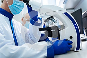 Experienced researcher using a microscope in the lab