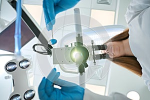 Experienced stomatologist examining patient using modern diagnostic equipment