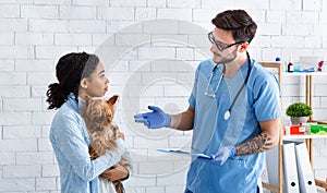 Experienced veterinarian doctor talking to client in medical office