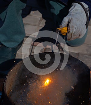 An experienced welder at work. Preparation and welding process of cast iron furnace. Selection focus. Shallow depth of field