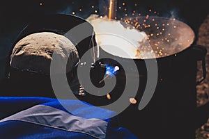 An experienced welder at work. Preparation and welding process of cast iron furnace. Selection focus. Shallow depth of field.